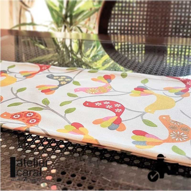 Camino de mesa antimanchas con pájaros multicolores sobre fondo blanco – Estilo lúdico y moderno de Atelier Caral