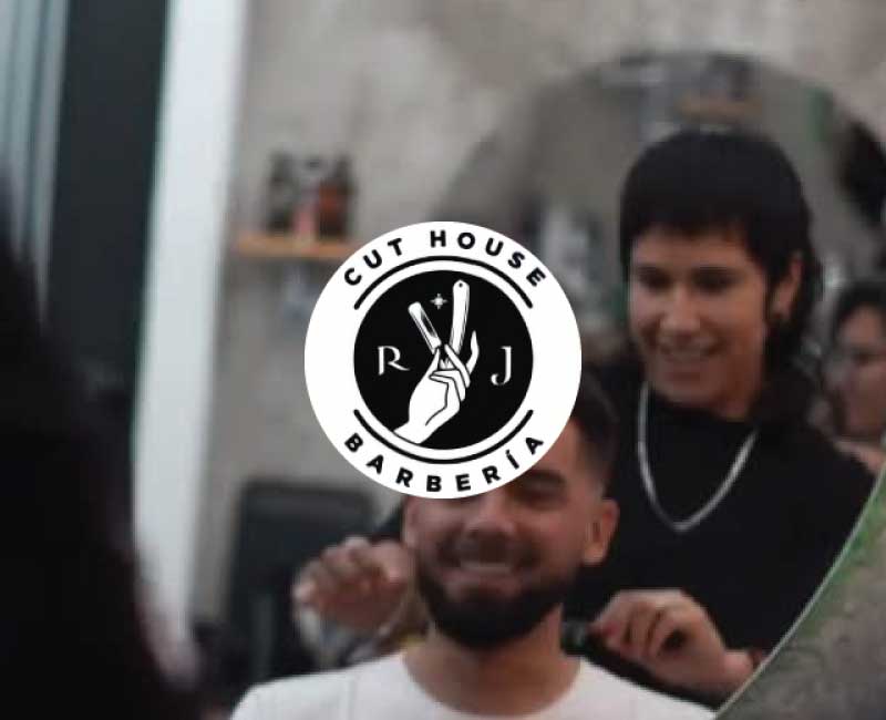 Estilista de Cut House Barbería realizando corte personalizado en ambiente moderno y profesional