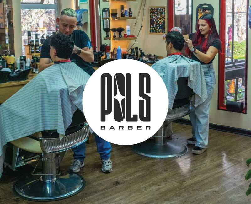 Pols Barber, barbería en Bodega Italia, Providencia, con profesionales realizando cortes de cabello masculino y el logotipo de la marca.