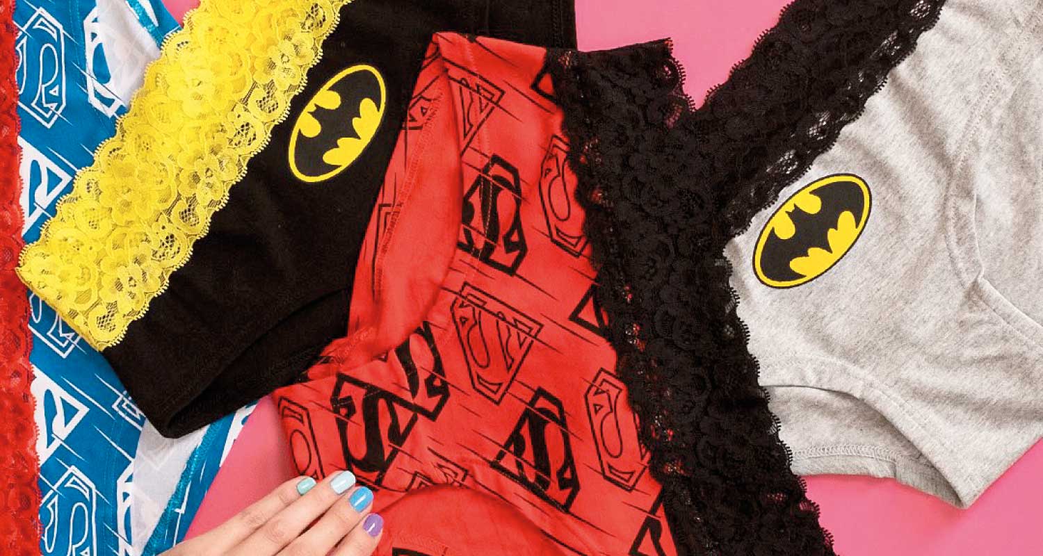 ropa-interior-superheroes-encaje-colorido-capitan-style Ropa interior femenina con diseños de superhéroes y encaje en colores vibrantes sobre fondo rosado – Capitán Style en Bodega Italia