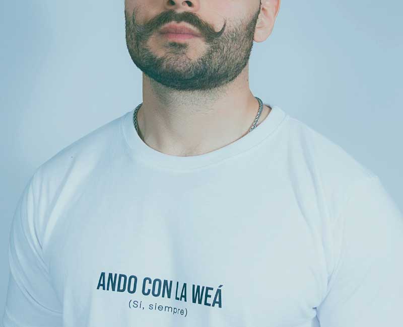 zamu-polera-blanca-ando-con-la-wea-frase-chilena-diseno-local Hombre usando polera blanca ZAMU con frase "Ando con la weá", diseño chileno con identidad y humor local