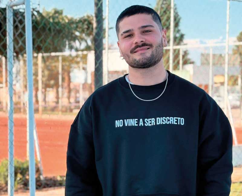 zamu-poleron-negro-no-vine-a-ser-discreto-diseno-frontal-estilo-urbano Hombre vistiendo polerón negro ZAMU con frase "No vine a ser discreto", moda urbana con actitud y diseño de autor chileno