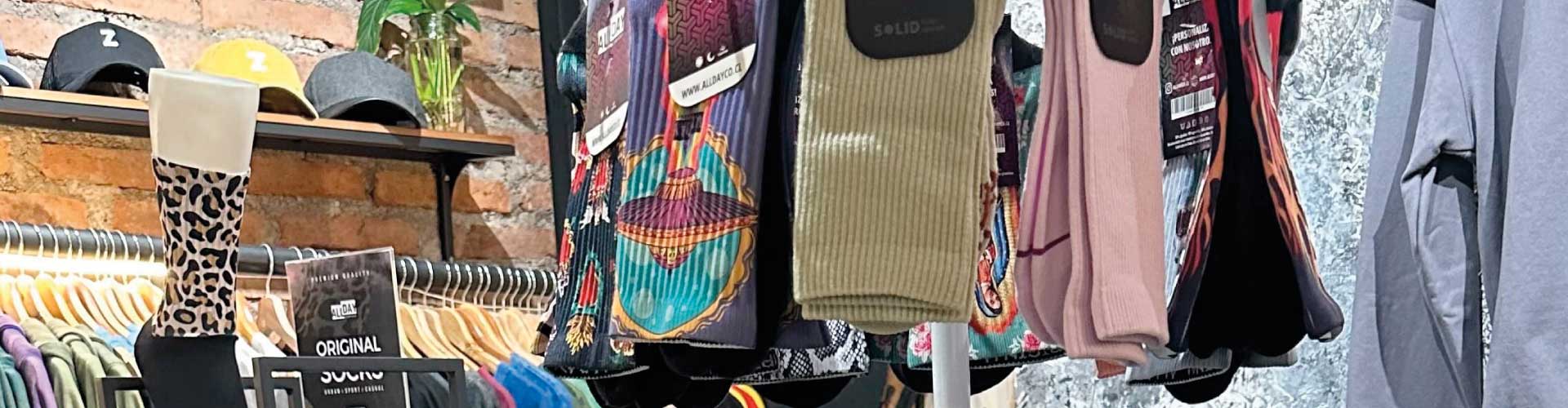 zamu-tienda-accesorios-calcetines-diseno-chileno-barrio-italia Interior de la tienda ZAMU en Bodega Italia con exhibición de calcetines de diseño chileno, gorros y ropa urbana con identidad local